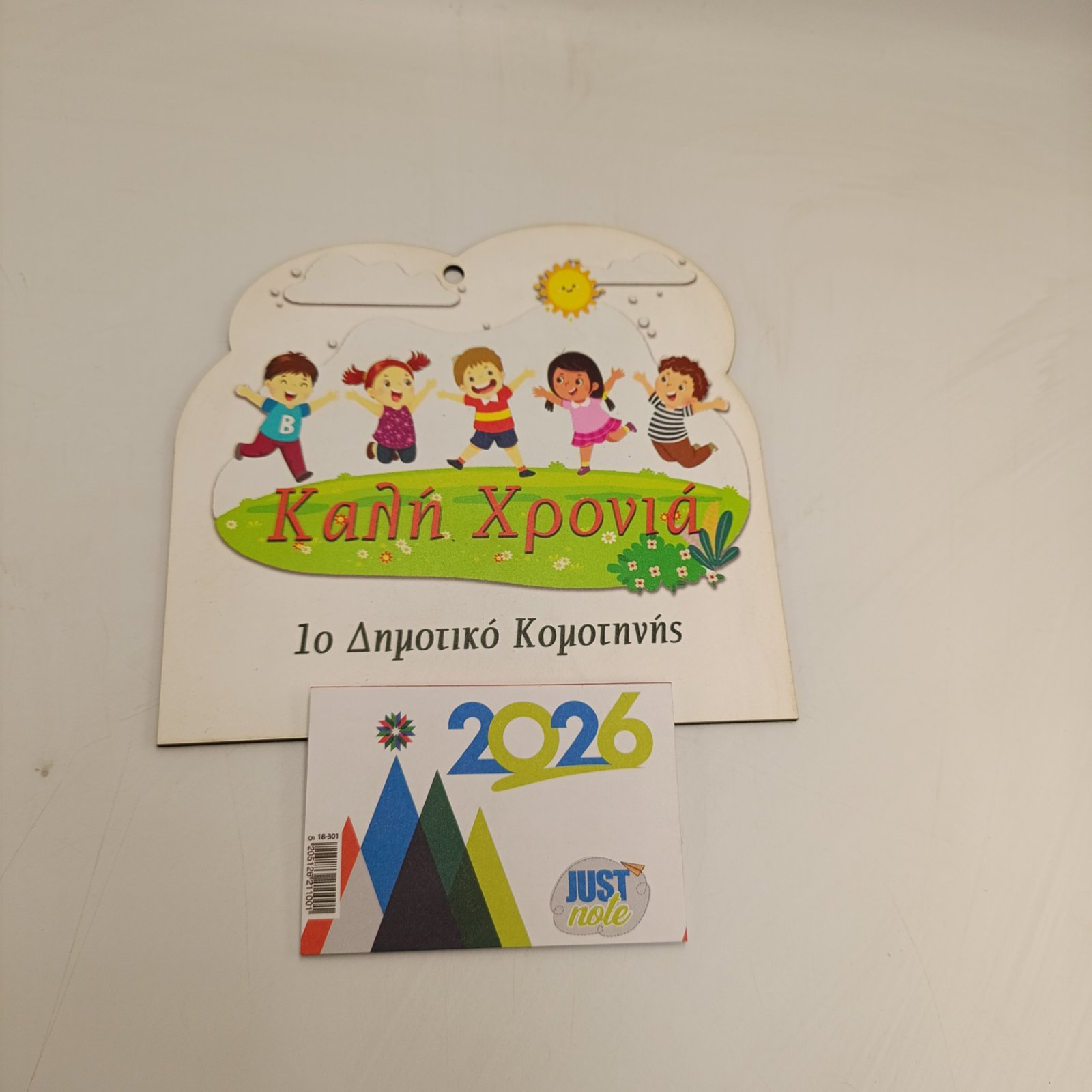 Επιτοίχιο ξύλινο ημερολόγιο με έγχρωμα χαρούμενα παιδιά, ευχή Καλή Χρονιά και όνομα σχολείου